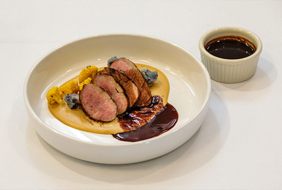 Entrée: Seared Pork Medallions. Seared pork tenderloin on top of carrot puree, served with poached cauliflower with a black garlic and red wine reduction