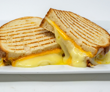 Five cheese panini offered at Bread Box, with the cheese melting out onto the plate