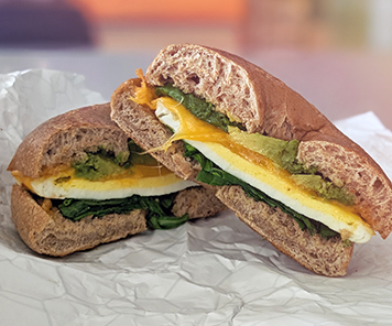 Power Bagel consisting of egg, cheddar, spinach and avocado, served on a grain bagel - this sandwich is only available at Corner Cafe