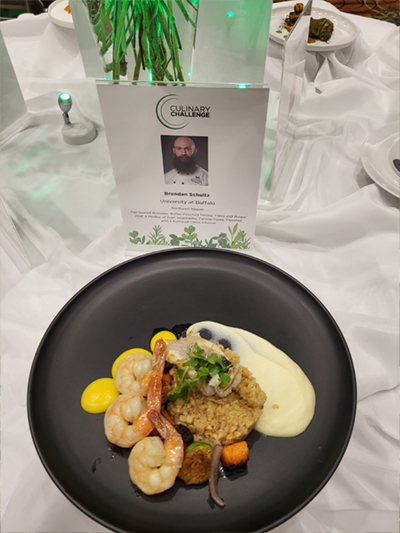 Chef Brendan's plated dish with his plaque with information behind it