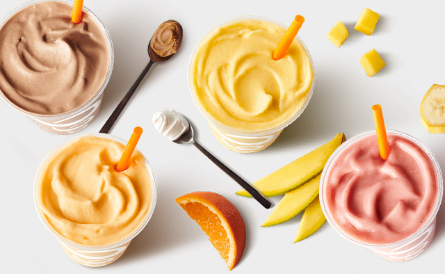 Top down view of peanut butter, orange, mango, and strawberry banana smoothies