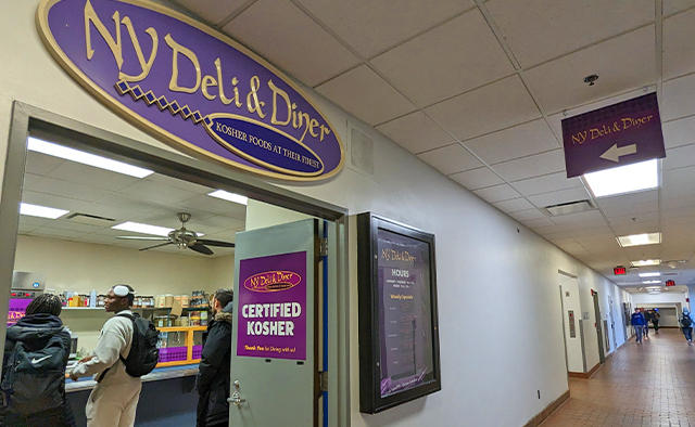 The hallway in Talbert Hall that leads to the NY Deli entrance, with the logo signage hanging above the door