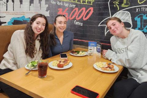 Three students eating pizza together at Governors Dining Center