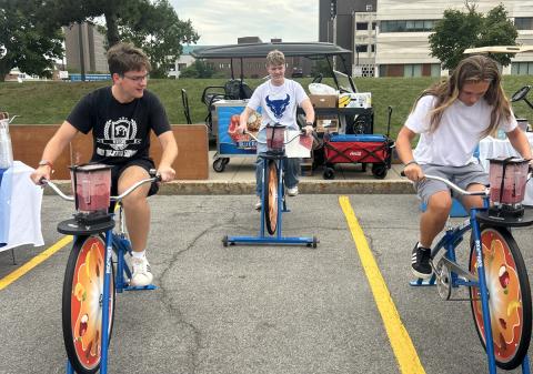 Three students riding blender bikes