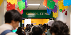 Sabor Latino logo above the entrance door, with students lining up in front of it
