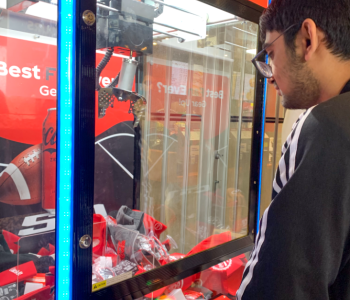 Student using the Coke claw machine