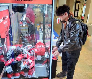 Student using the Coke claw machine