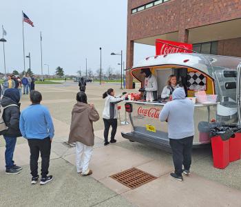 Coca Cola ambassadors serving guests from the Coca Cola Throwback car