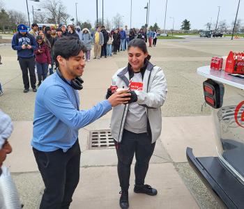 Two students clinking their Coca Cola floats together