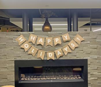 Banner that reads "Happy Holidays" hanging from the Crossroads (C3) fireplace.