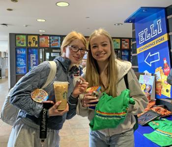 Two students holding cereal cups and a Lucky Charms shirt.