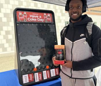 Student smiling showing off their Coca Cola prize