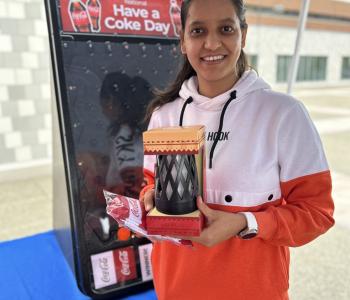 Student smiling showing off their Coca Cola prize