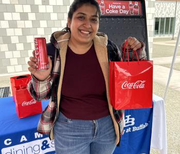 Student smiling showing off their Coca Cola can and their prize