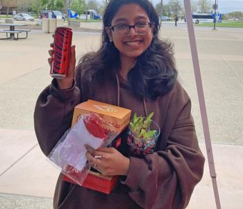 Student smiling showing off her Coca Cola can and Coca Cola prize