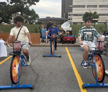 Three students riding blender bikes
