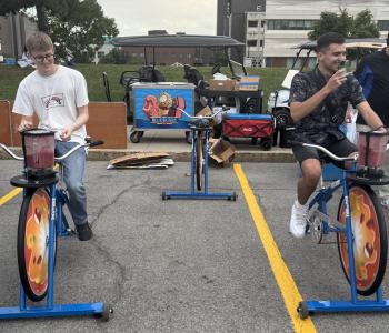 Two students riding blender bikes