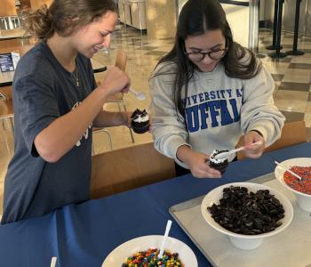 Two students decorating their cupcakes