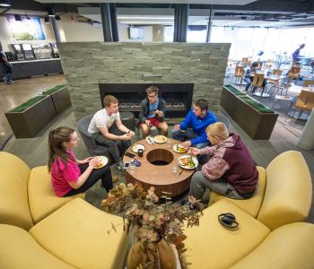 Students dining at C3 near the fireplace. Photo by Onion Studio.