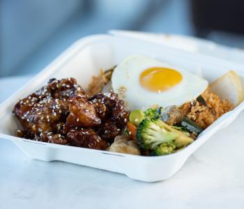 Sesame chicken with vegetables, kimchi rice and fried egg from Pan Asia. Photo by Onion Studio.