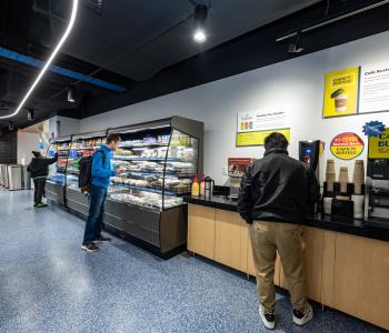 Students choosing items from the grab & go section and beverage station of One World Café. Photo by Onion Studio.