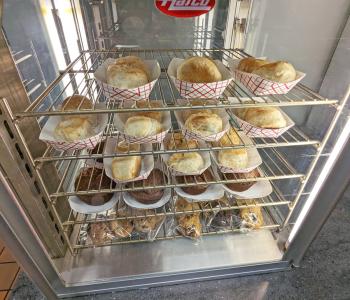 Potato knish, muffins, and cookies in the warmer ready to be served.