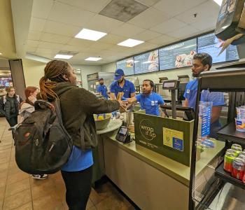 A student receiving their food from the Wrap it Up order counter.