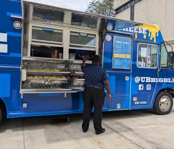 Big Blue food truck parked on South Campus. A customer is ordering food.