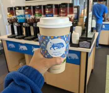 Coffee cup with a Bulls on the Run coffee sleeve
