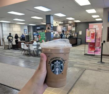 Iced coffee from Whispers Café in front of the cafe inside Abbott Library.