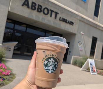 Iced coffee from Whispers Café in front of the entrance to Abbott Library.