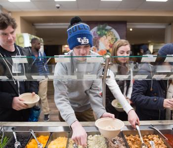 Students reaching for toppings for their bowls. Photo by Onion Studio.